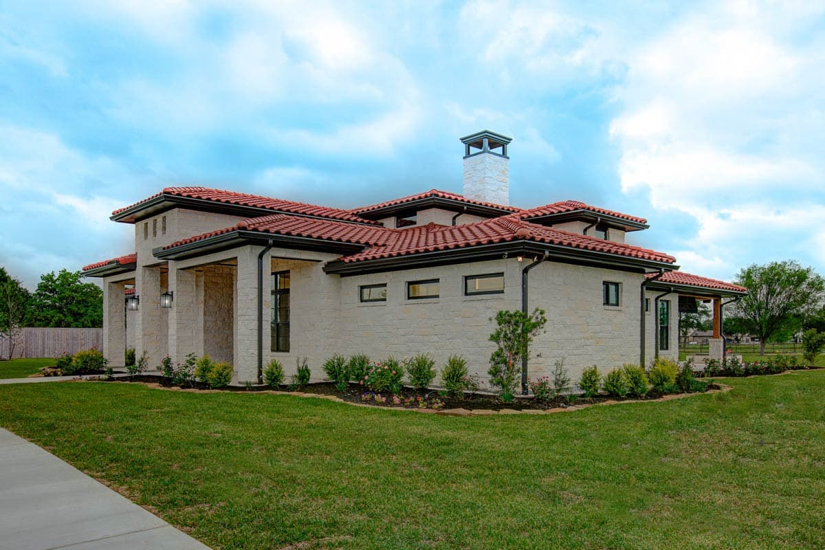 House plan exterior: Modern home with red tile roof, stone facade, open-air entry, and a tall square chimney.