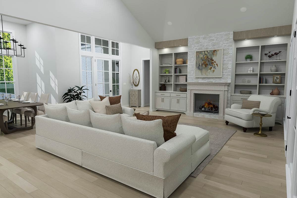 Great room with vaulted ceiling, fireplace flanked by built-in bookshelves, and large windows.