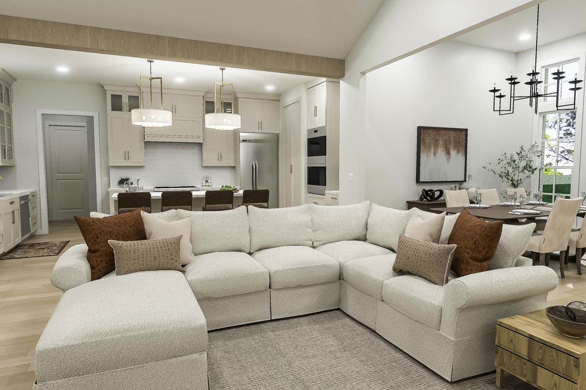 Open-concept living area with vaulted ceiling, large sectional sofa, kitchen island, and dining room.