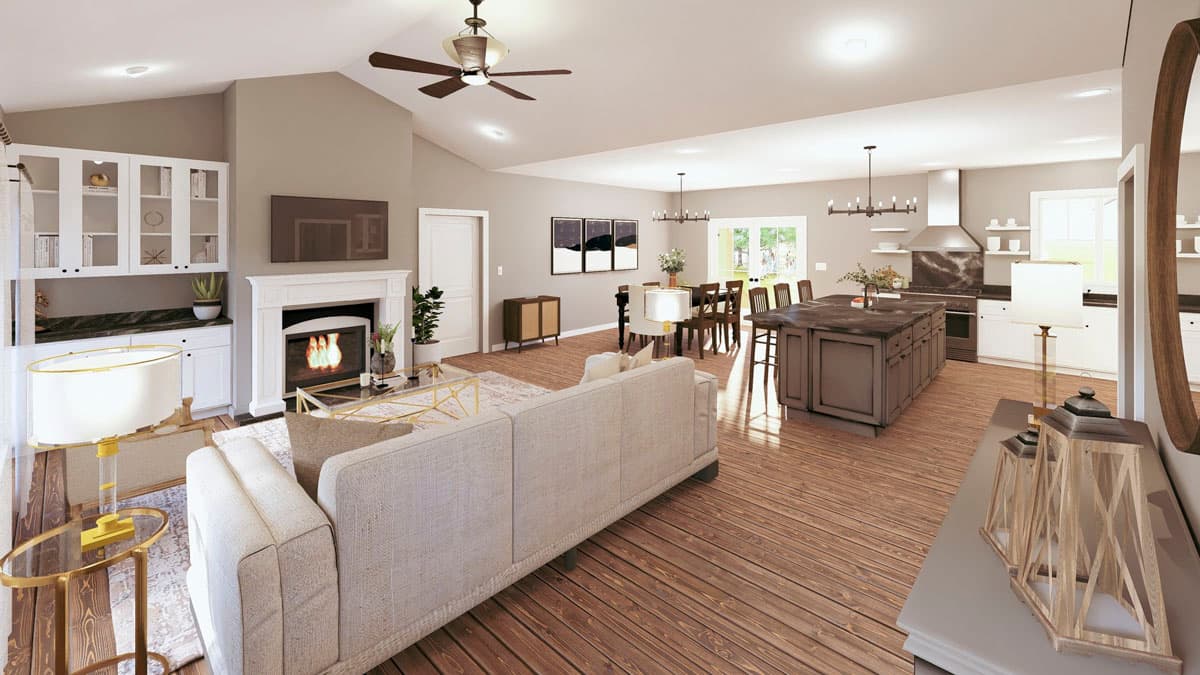 Open concept living area featuring a vaulted ceiling, fireplace, kitchen island, and dining area.