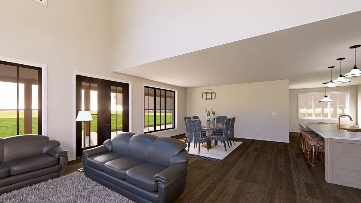 Open concept living area with sofas, dining table, and kitchen island featuring pendant lighting.