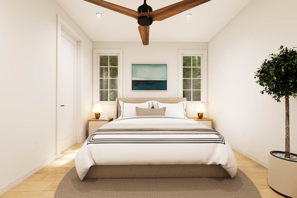 A modern bedroom with a bed, art, two windows, two nightstands, and a ceiling fan.