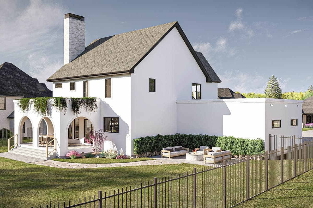 House plan exterior: White stucco, arched loggia with hanging plants, tall stone chimney, and multi-level rooflines.