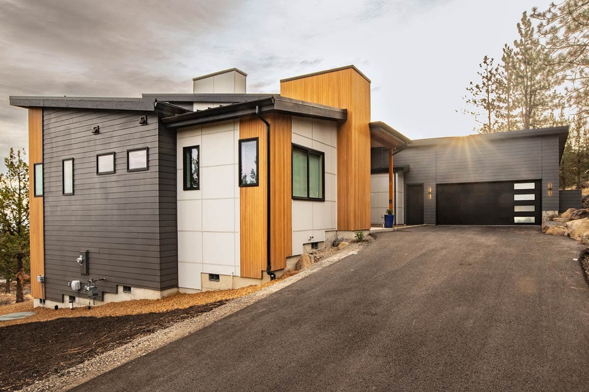 House plan exterior. Modern style, two-story home with flat roof, vertical wood siding accents, and attached garage with black door.