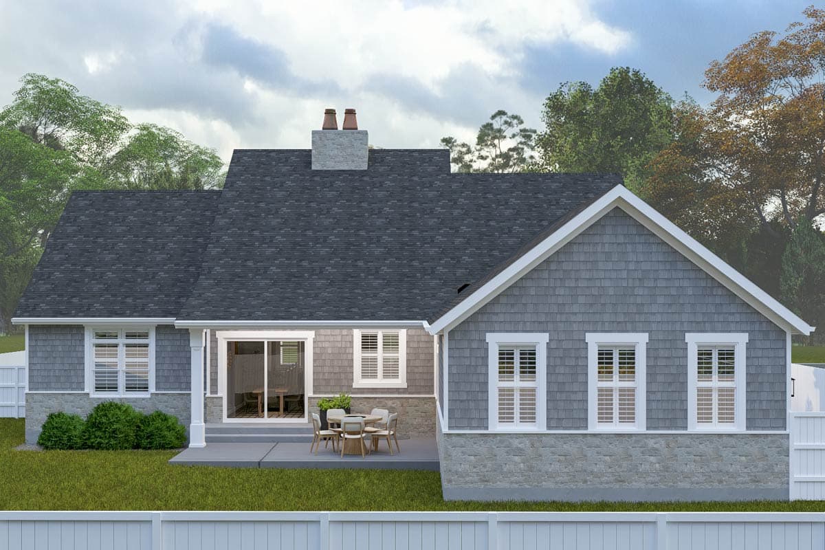 House plan exterior: single-story home with shake siding, stone foundation, dual chimneys, and patio access via sliding glass doors.