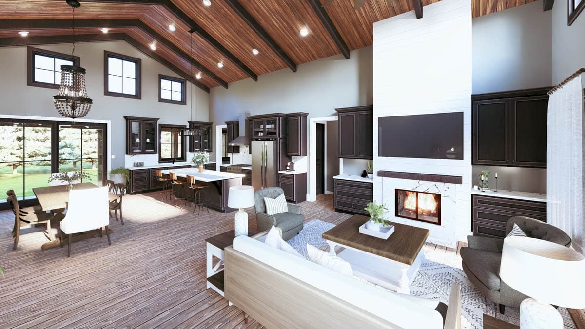 Open concept living area with vaulted wood beam ceiling, kitchen island, fireplace with TV, and dining area.