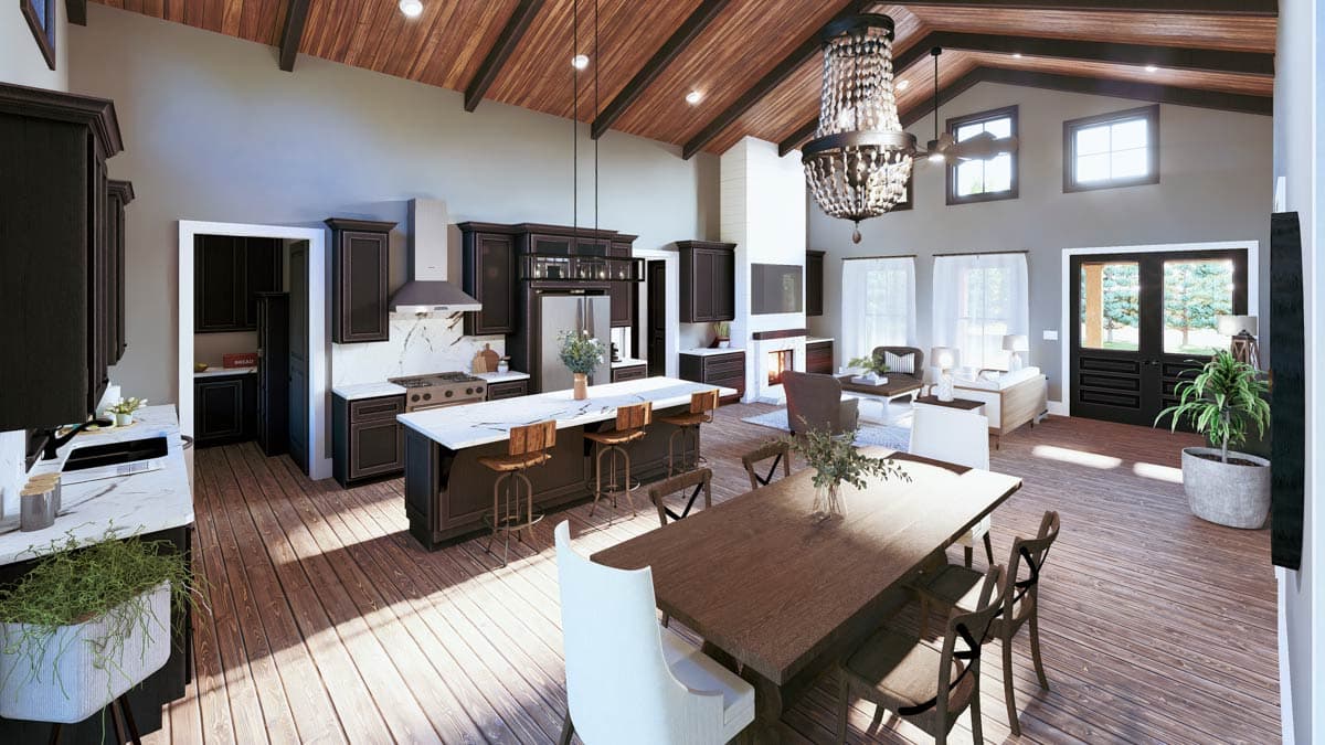 Open concept living space featuring a kitchen island, dining area, and great room with vaulted ceiling and fireplace.