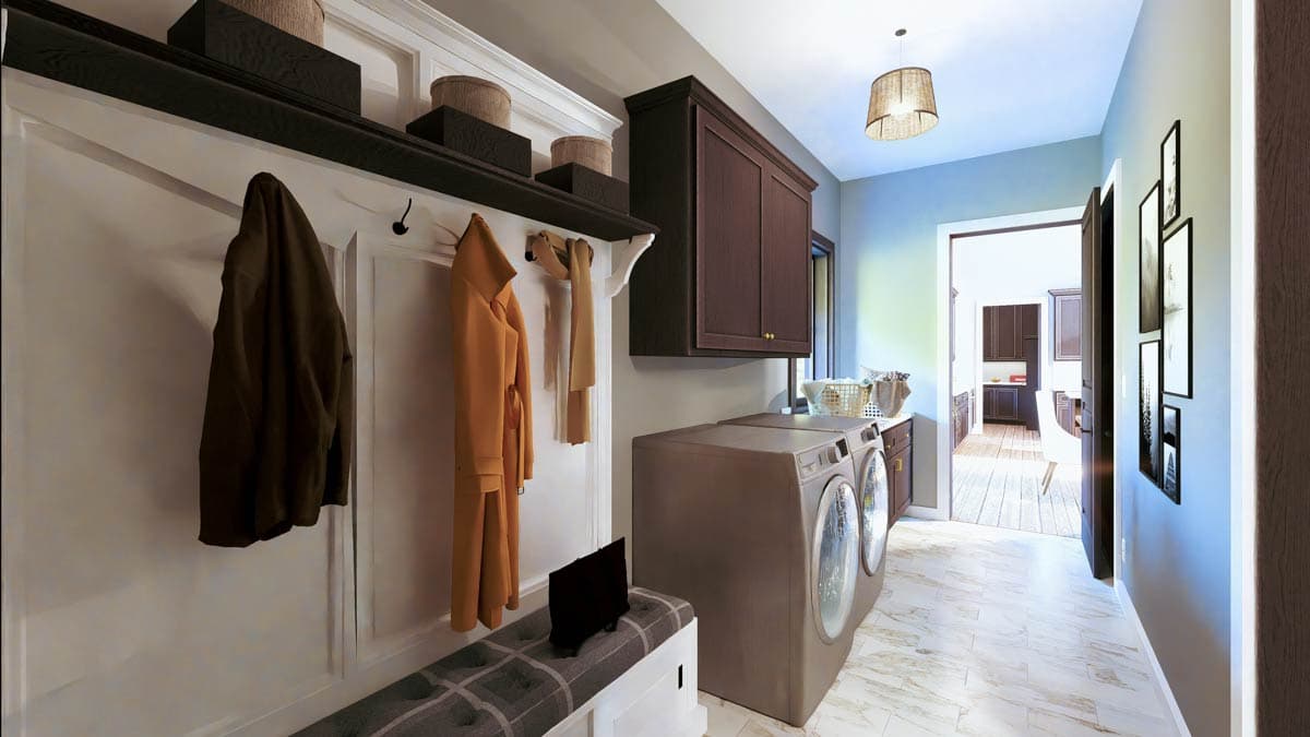 Laundry room with washer, dryer, built-in bench, dark wood cabinets, and entry to kitchen.