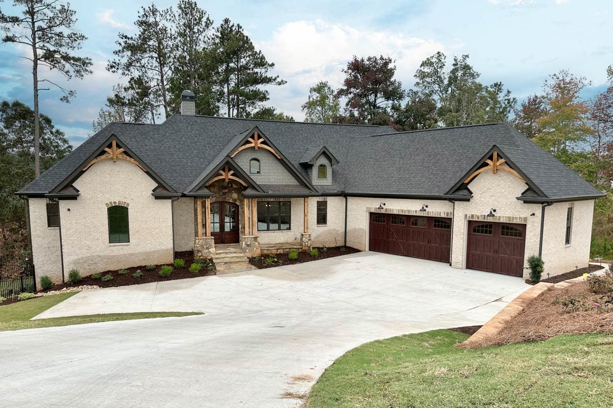 House plan exterior. Craftsman style home with one story, prominent gables, exposed rafter tails, and a front-facing, multi-car garage.