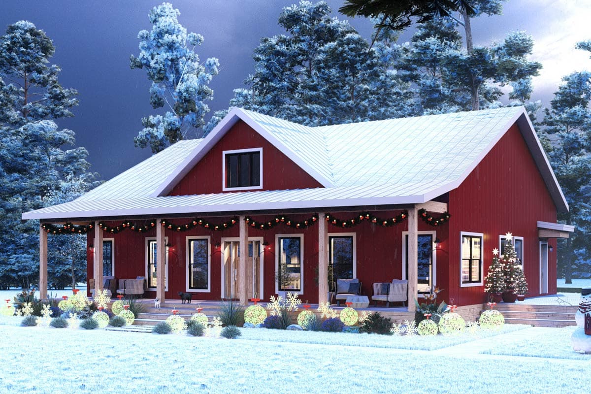A festive red house with a snow-covered roof and porch, decorated for Christmas. Illuminated ornaments and a small Christmas tree adorn the front.