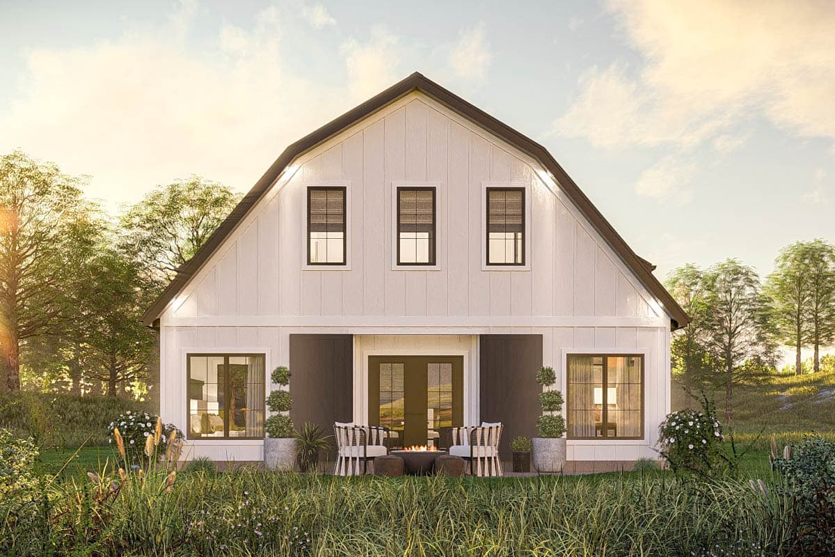 Modern farmhouse exterior with gambrel roof, board and batten siding, and covered patio with seating.