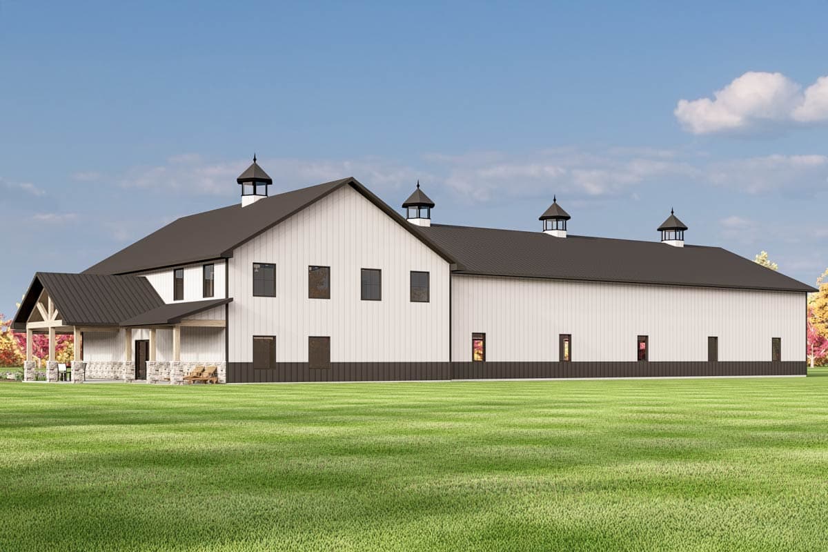 House plan exterior: Long, white Modern Farmhouse style building with dark roof, cupolas, and a covered porch with stone pillars.