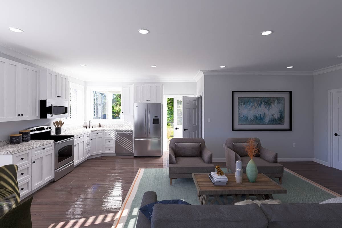 Open concept living area and kitchen with white cabinets, stainless steel appliances, and natural light.