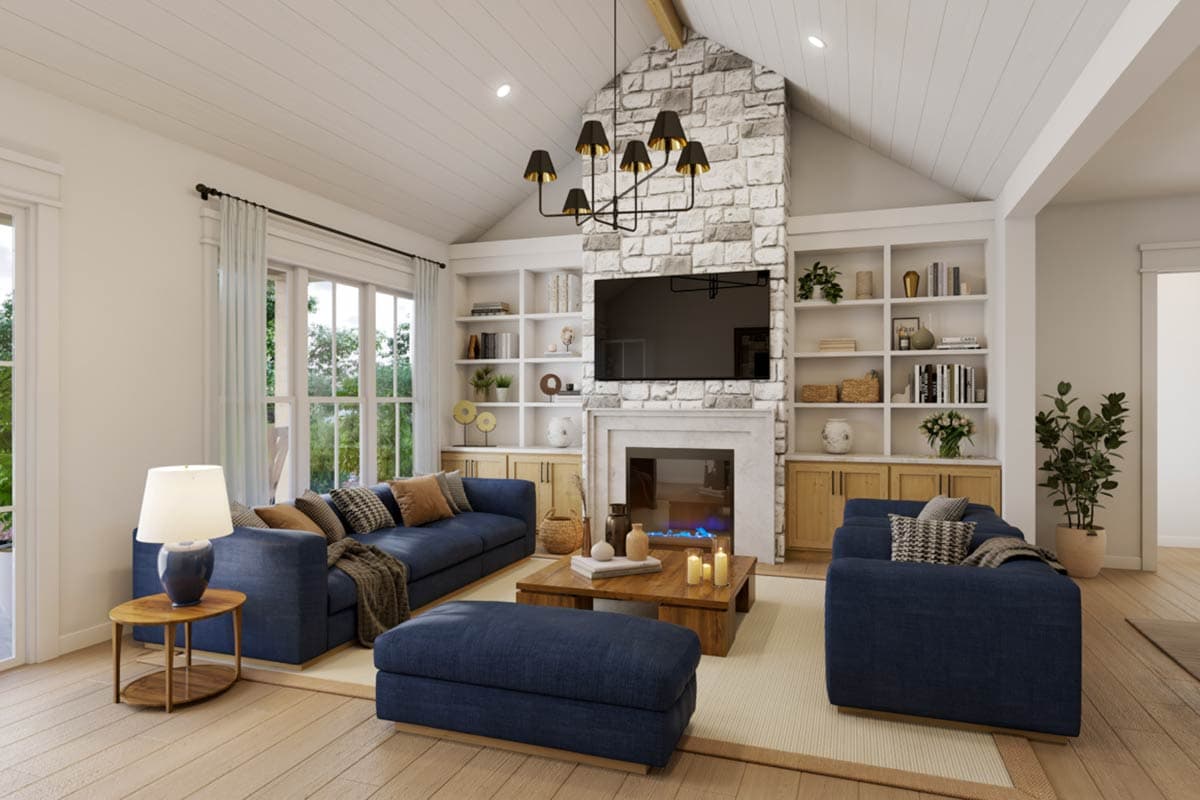 Living room with vaulted ceiling, stone fireplace, built-in bookshelves, and large windows.
