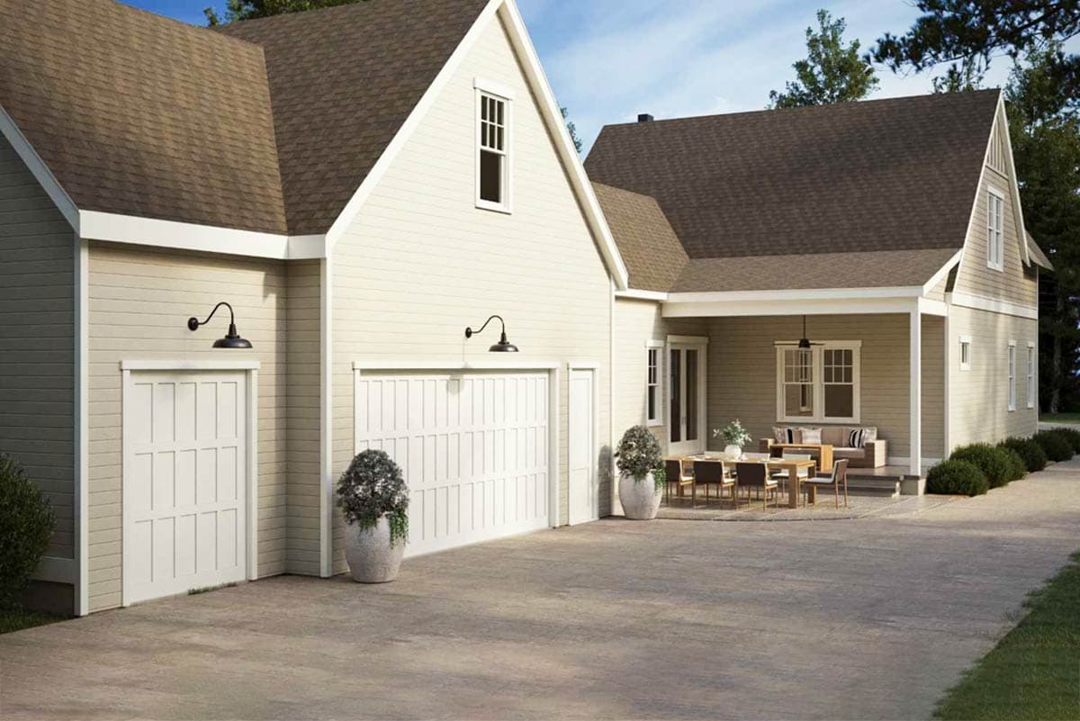 House plan exterior with a two-car garage, covered porch, multiple gables, and siding.