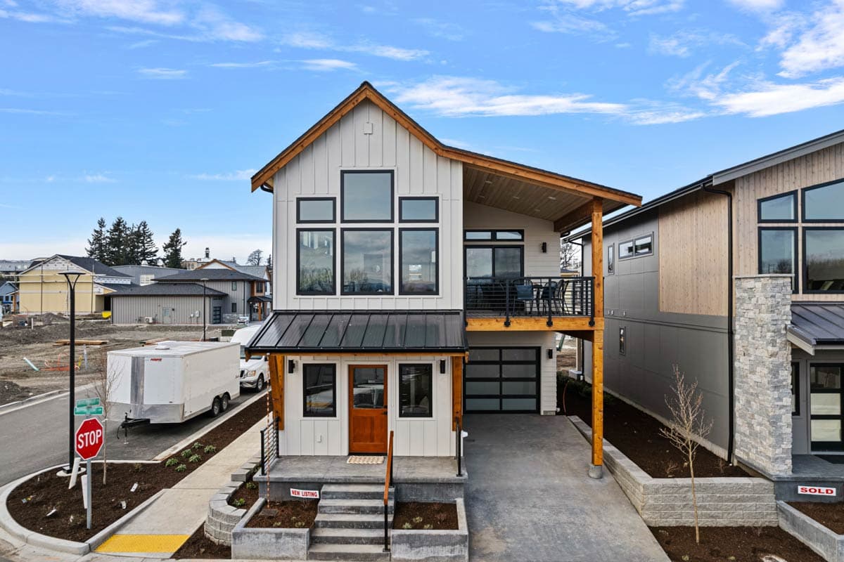 Modern Farmhouse house plan exterior with two stories, a front porch, a shed-style roof, and a detached garage.