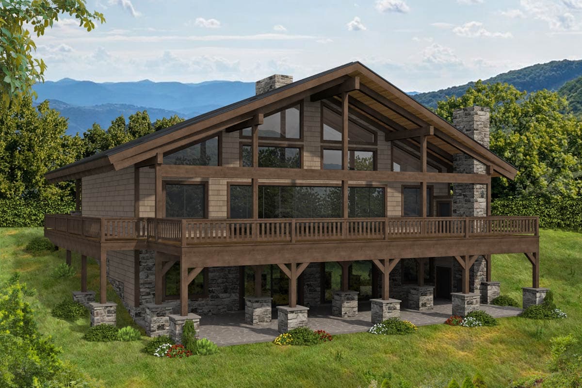 House plan exterior with two stories. Features a gabled roof, a large deck, and a stone chimney. Timber frame detailing is prominent.