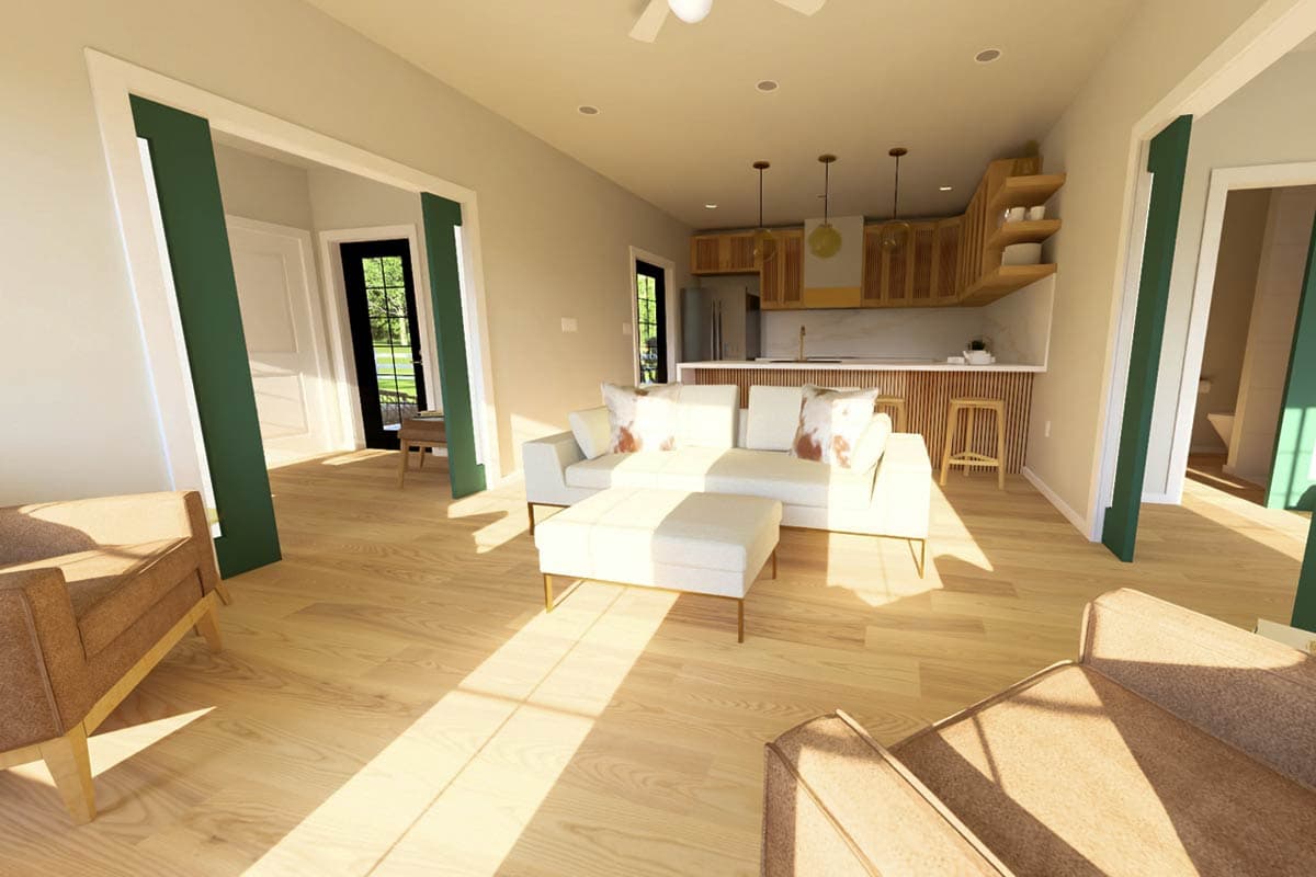 Open concept living area with white sectional sofa, kitchen island with pendant lights, and natural wood cabinetry.