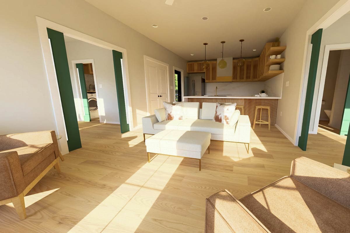 Open concept living area with sectional sofa, kitchen with wood cabinetry and island, view to laundry room.
