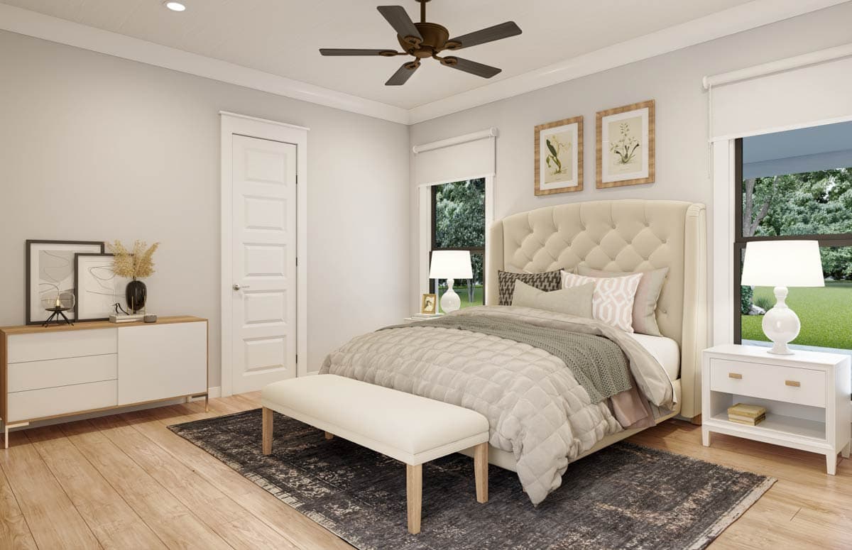 Bedroom interior. Bed with a tufted headboard, nightstands with lamps, rug, and a ceiling fan. Neutral colors and a bench complete the space.