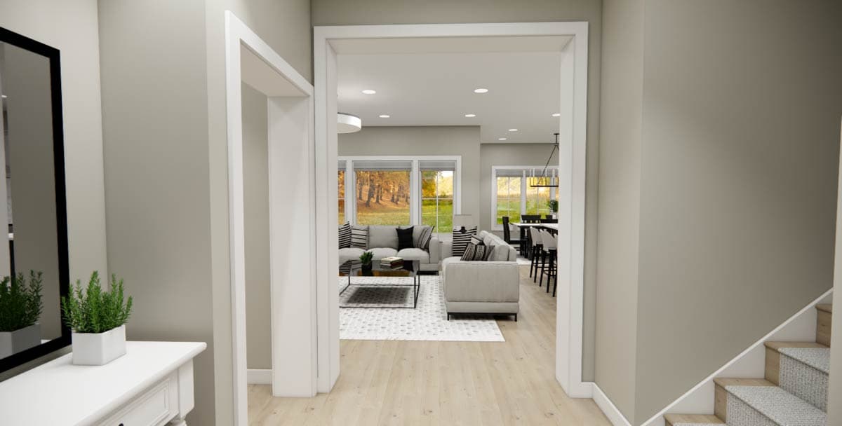 Open concept living and dining area with large windows, sectional sofas, and pendant lighting. Floor plan.