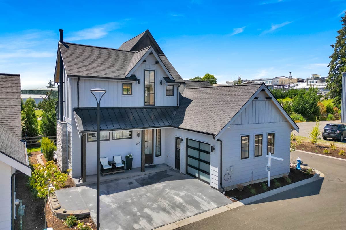 Modern Farmhouse house plan exterior with vertical siding, gables, metal roof, and attached garage.