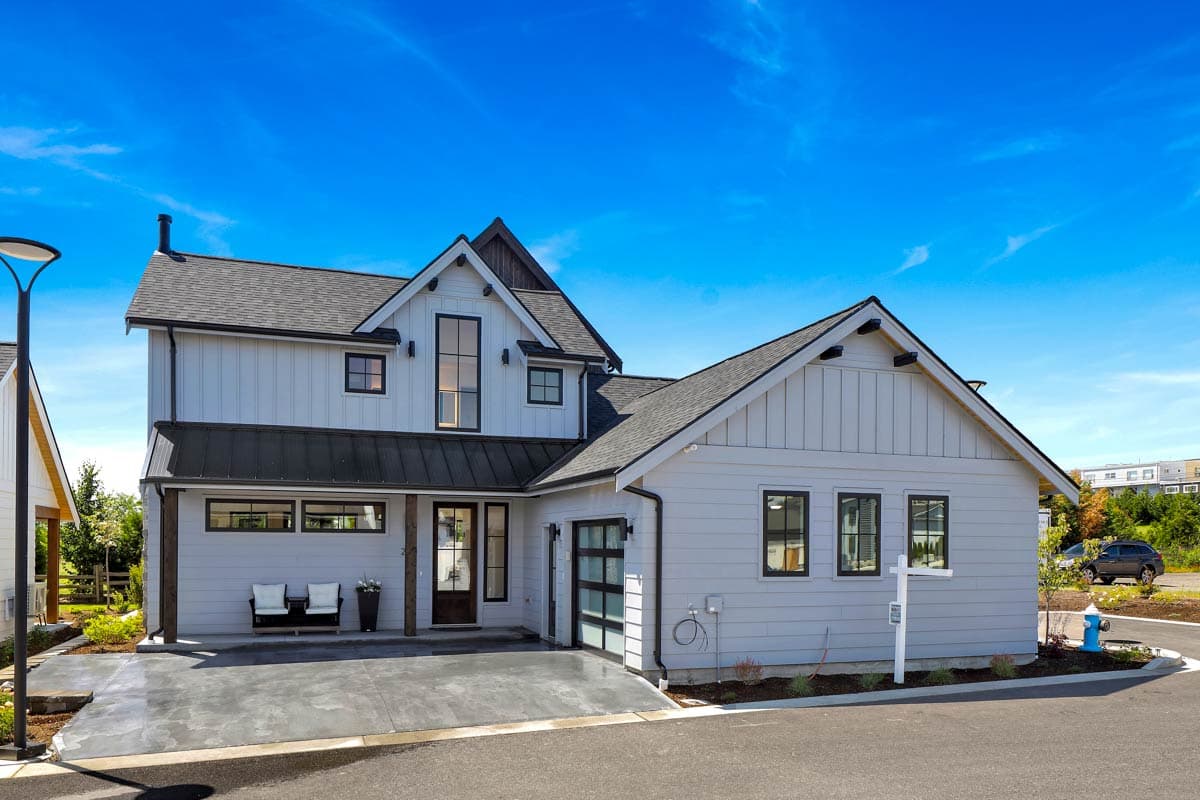 Modern Farmhouse style house plan exterior, two stories, with gables, dormers, a metal roof porch, and attached garage.