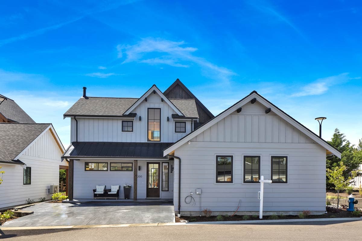 Modern Farmhouse house plan exterior with board-and-batten siding, a metal roof, gables, and a two-car garage.