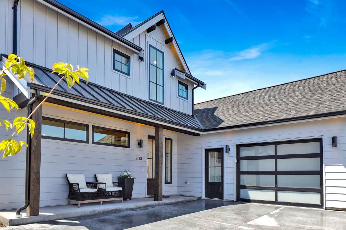 Modern Farmhouse house plan exterior with board and batten siding, gabled rooflines, covered porch, and glass-paneled garage door.