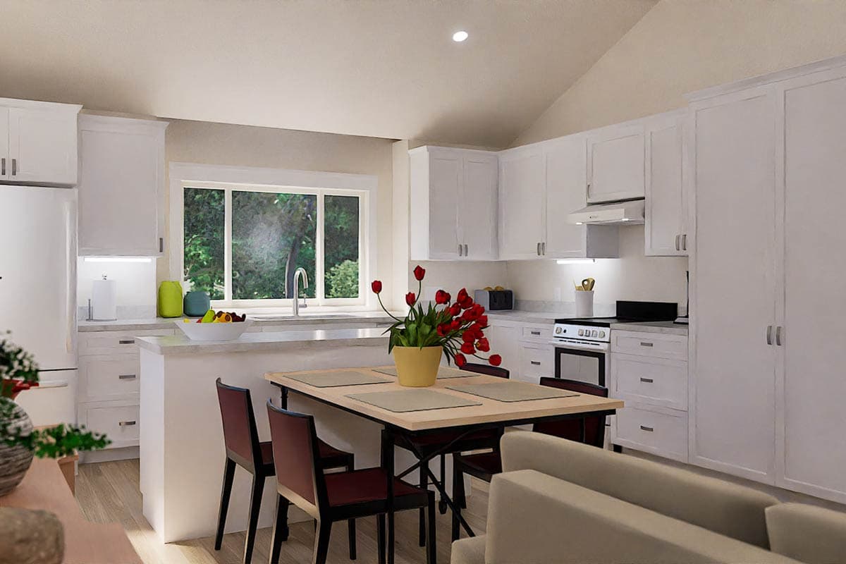 A modern kitchen with white cabinets, a dining table set for four, and a bright window overlooking greenery, complete with a bouquet.