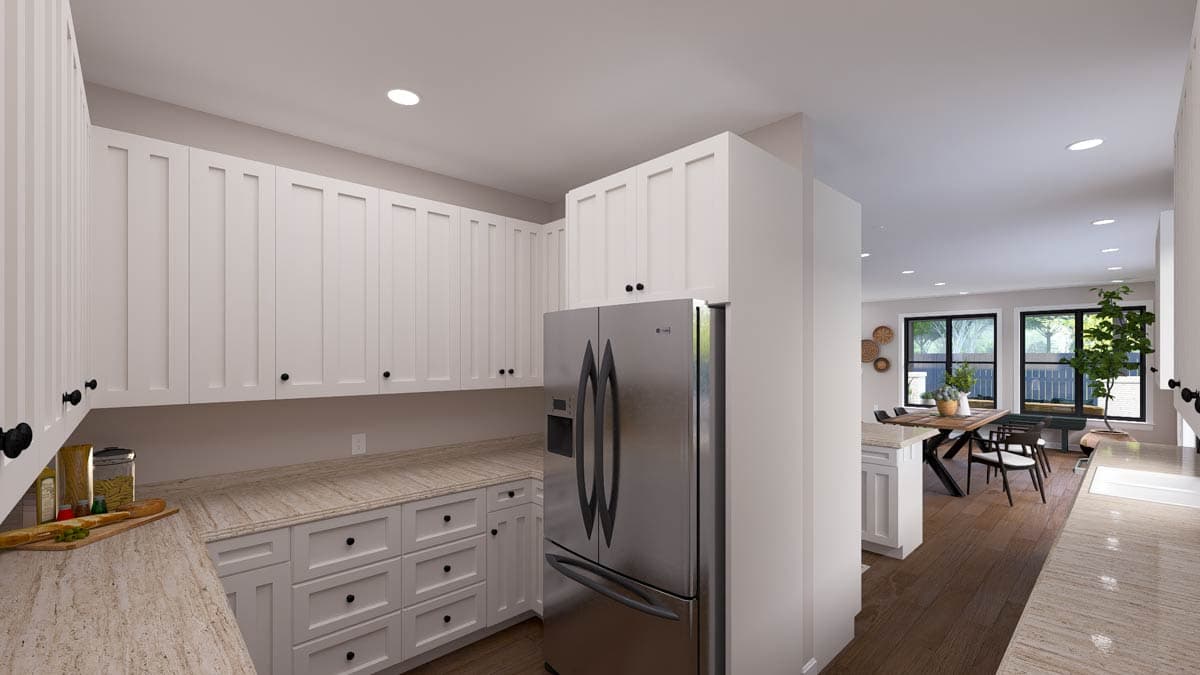 Kitchen with white Shaker-style cabinets, stainless steel refrigerator, and open view to dining area with wood table and chairs.