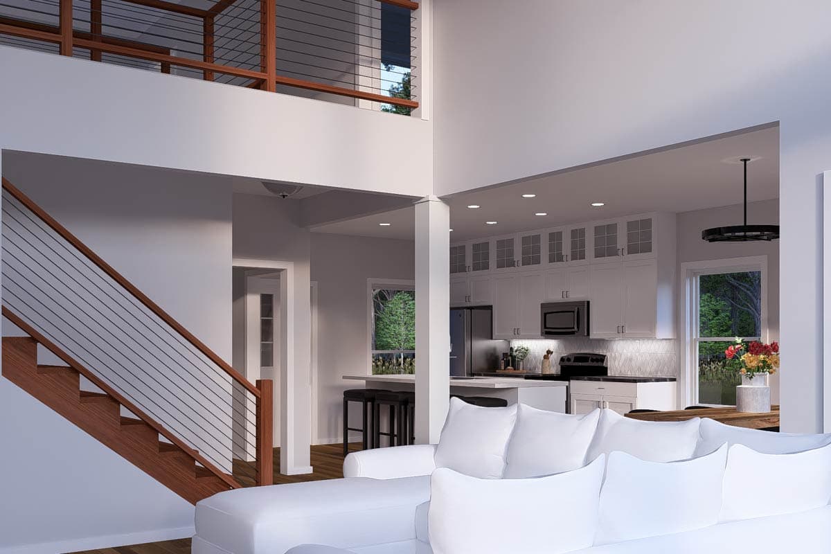 Open concept living area with modern staircase, white kitchen with island, and dining area with large window.
