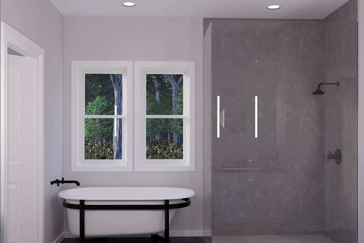 Bathroom with freestanding tub, dual-pane windows, and glass-enclosed shower with dark tile.