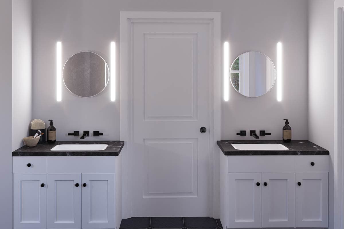 Bathroom with two vanities, each featuring a sink, black countertop, and linear wall sconces flanking a round mirror.