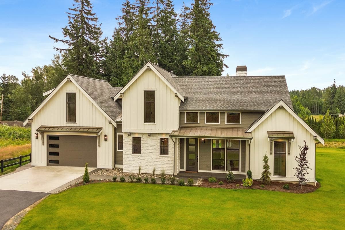 Modern farmhouse house plan exterior with gables, a metal-roofed entry, and a side-facing garage with horizontal windows.