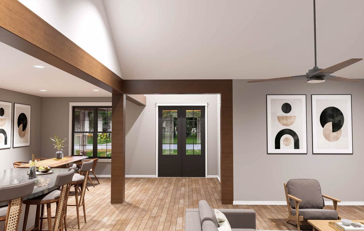 Interior view of a house plan, showing a dining area with island, vaulted ceiling with exposed beams, and French doors.