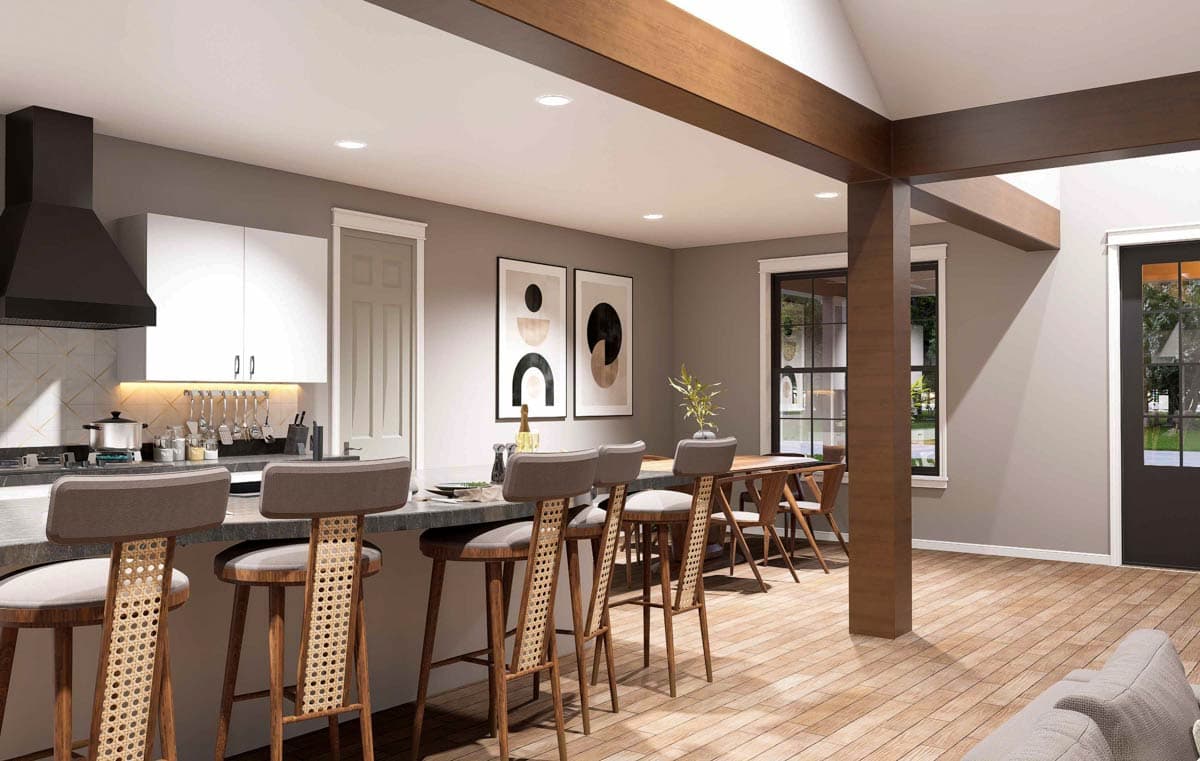 Open concept kitchen and dining area with island seating, wood beams, and natural light from large windows.