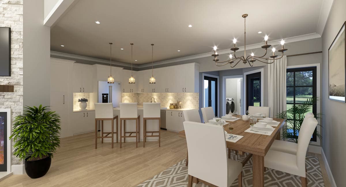 Open concept dining area and kitchen with island, white cabinets, and wood floors. Laundry visible through doorway.