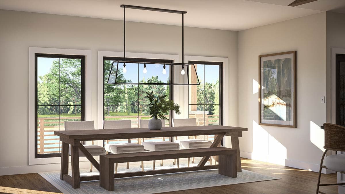 Dining room with dark wood trestle table, bench seating, and large windows overlooking trees.