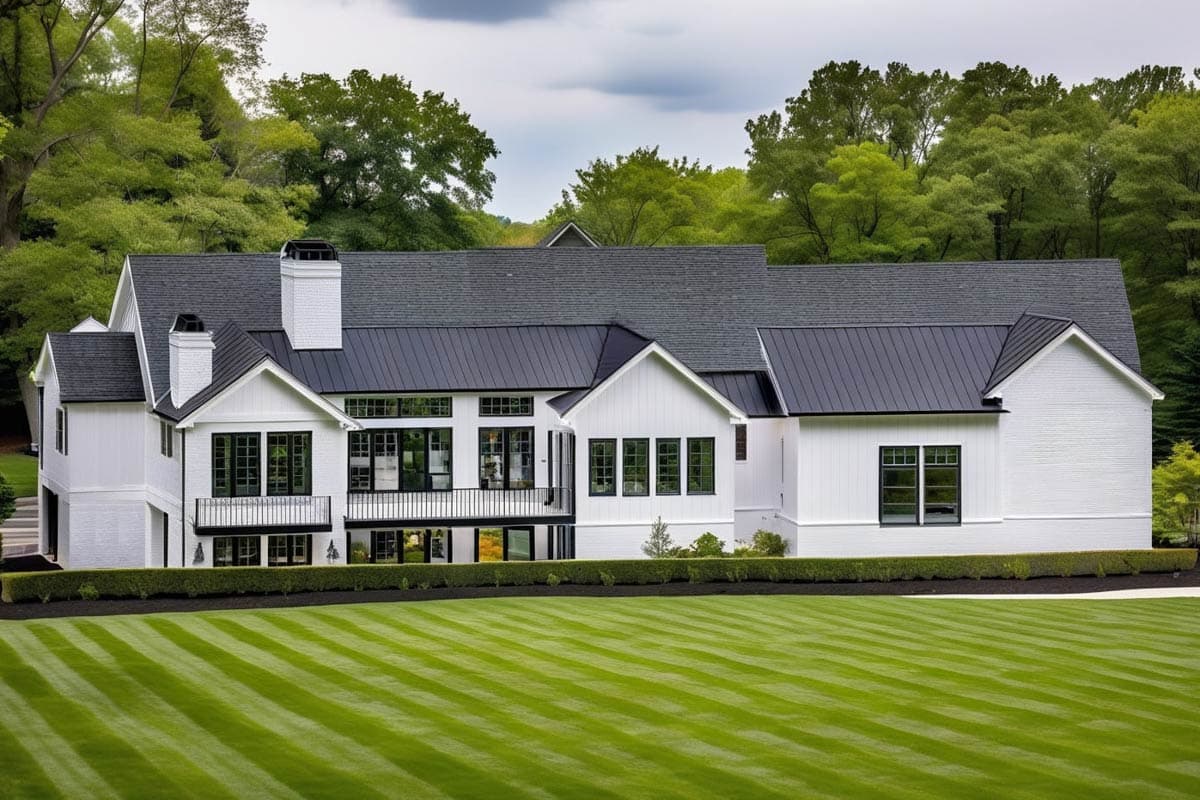 House plan exterior: Modern Farmhouse style, two stories, white siding, metal roof, prominent gables, and balcony.
