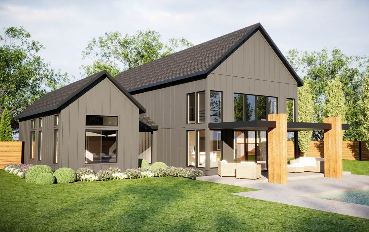 Modern farmhouse with gray siding, black trim, and large windows. Features a patio with seating and a lush green lawn.
