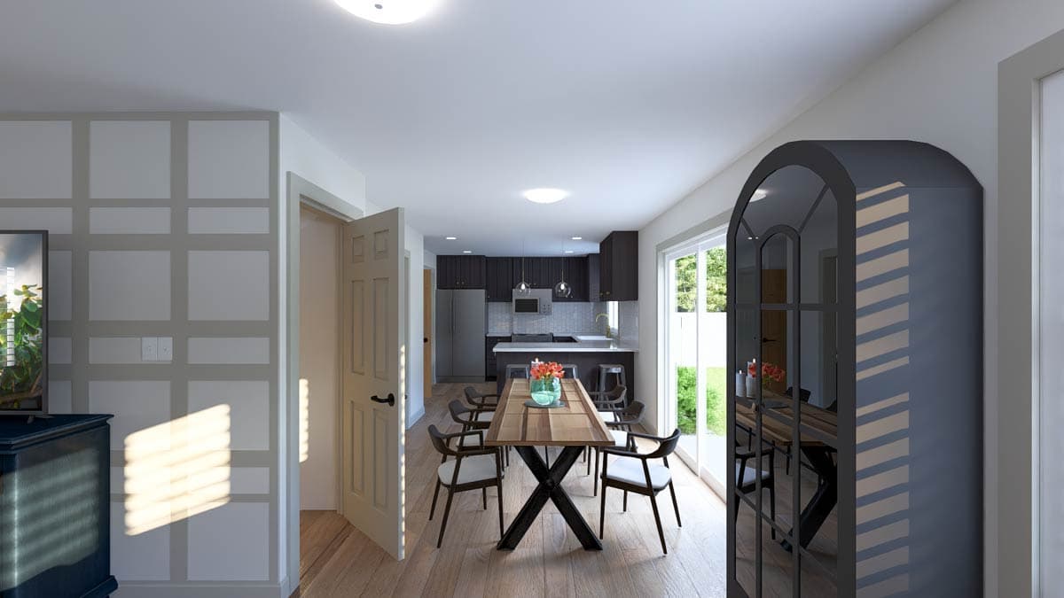 Open concept dining area with island kitchen, dark cabinetry, and large glass doors to the backyard.