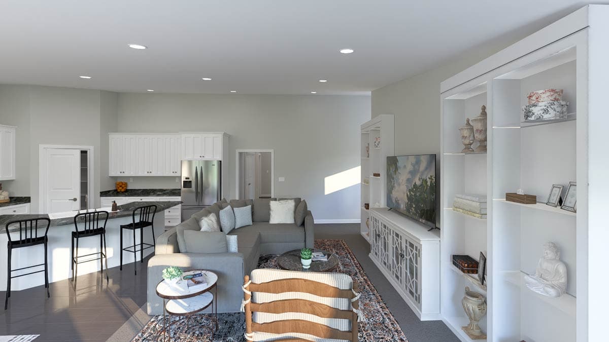 Open-concept living area with kitchen island, sectional sofa, TV console, and built-in shelving.