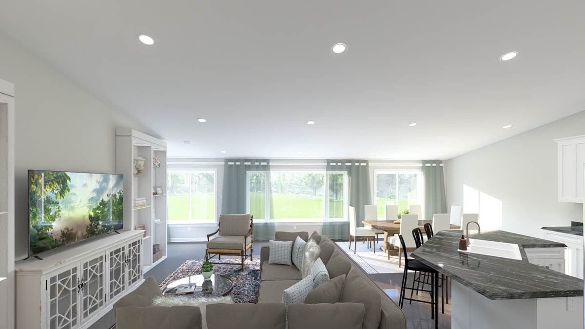 Open concept living area with sectional sofa, dining table, kitchen island, and large windows.