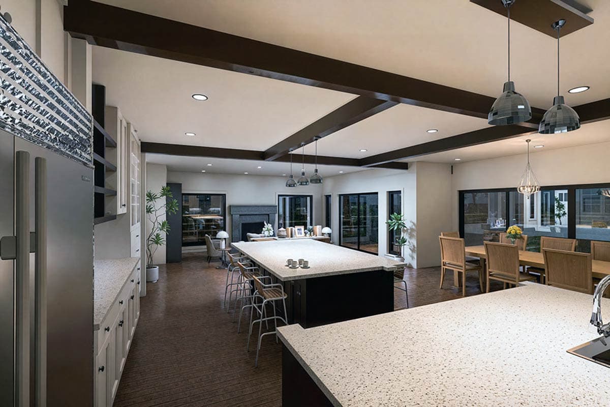 Open-concept kitchen and great room with large island, fireplace, beamed ceiling, and dining area.