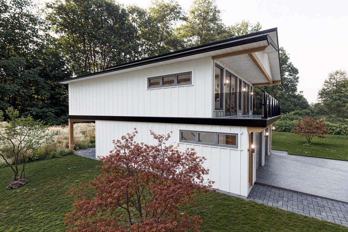 Modern house plan exterior with vertical siding, gabled roof, balcony, and large windows.