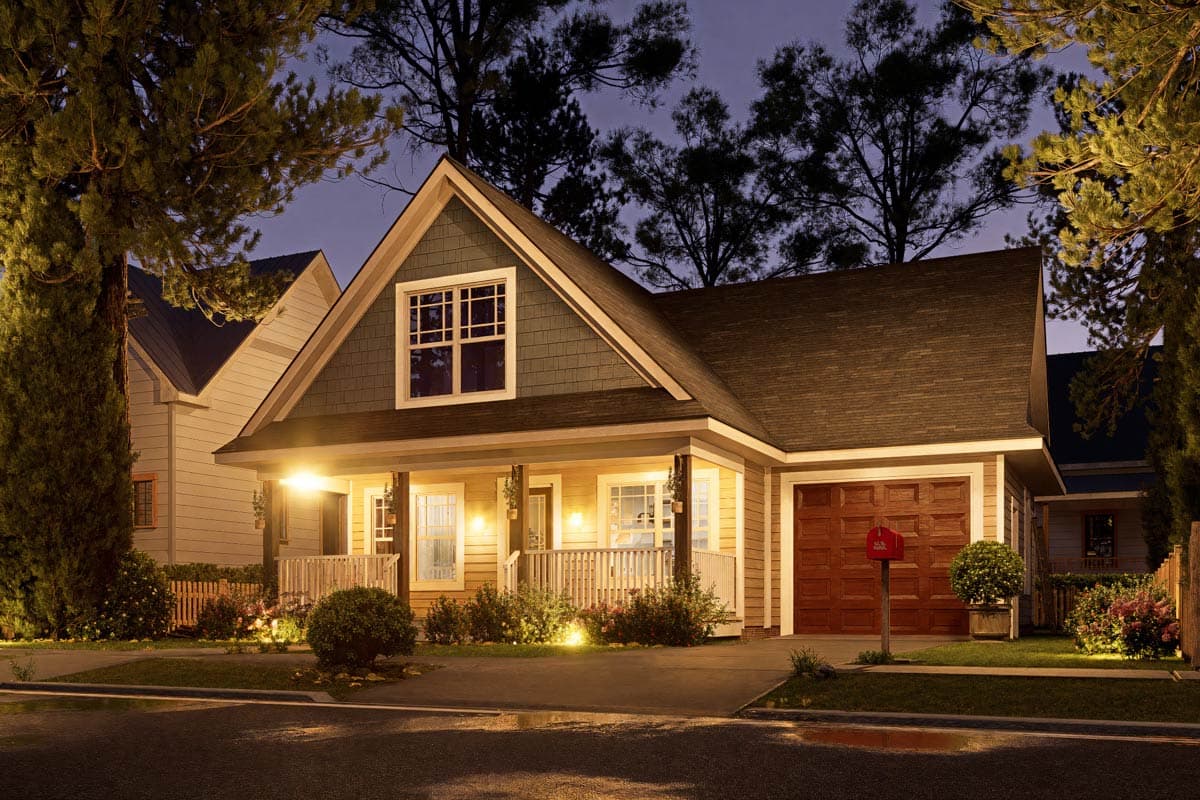 House plan exterior: Craftsman style, two stories, with a covered front porch, gabled dormer, and side-facing garage.