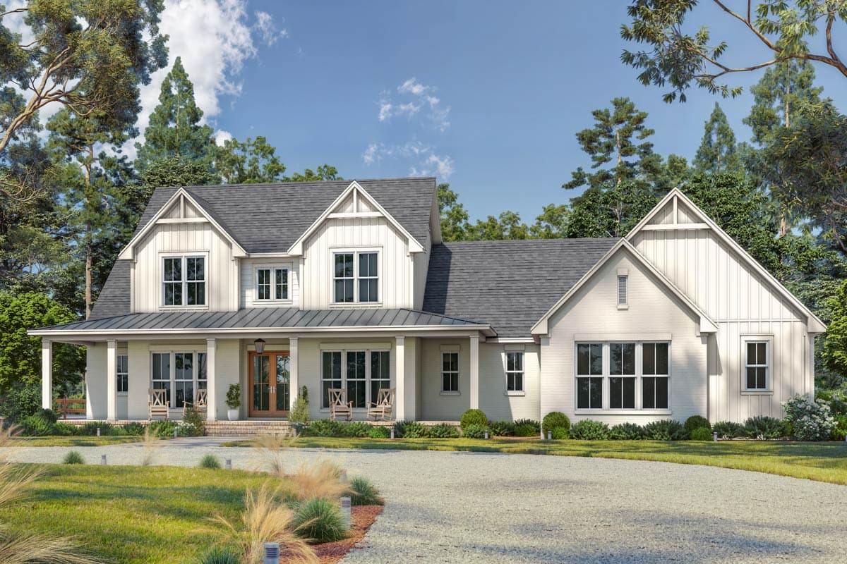 Exterior shot of a large, white farmhouse with a wraparound porch and gray roof, situated in a lush, green landscape.