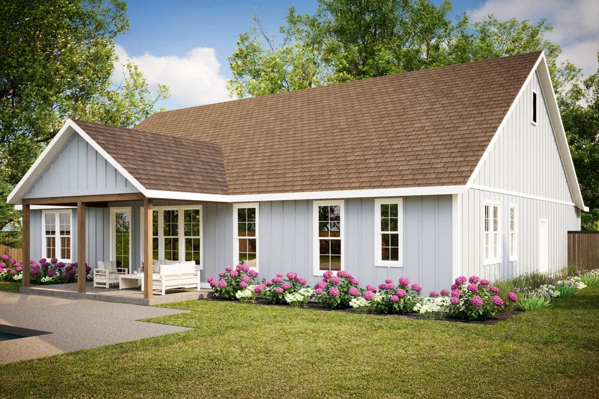 A modern farmhouse style house with light blue siding, brown roof, a covered porch, and flower beds in the front yard.
