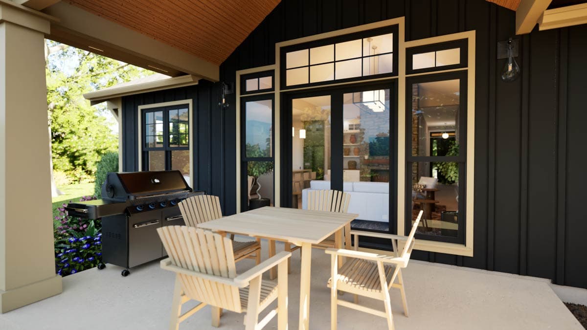 Modern house exterior with dark vertical siding, large windows, French doors, covered patio with dining set and grill.